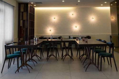 a dining room with tables and chairs against a wall at Apulia Praia Hotel in Esposende