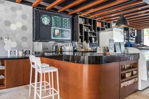a bar in a restaurant with two white stools at La Amada Residences Luxury in Cancún