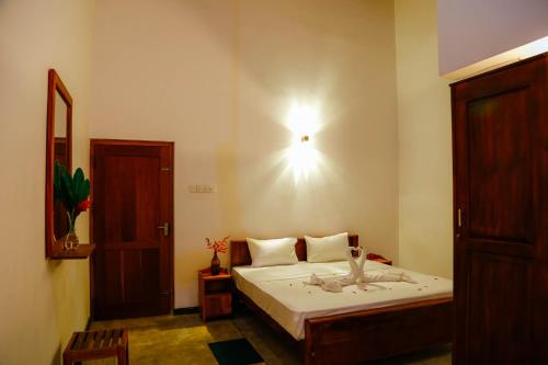a bedroom with a bed with a light on the wall at Paradise Beach House - 3 Bedrooms Apartment in Habaraduwa in Habaraduwa