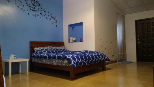 a bedroom with a bed with a blue wall at Happy Places in Yuanlin