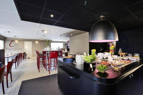 a restaurant with a table with food on it at Campanile Strasbourg - Illkirch Geispolsheim in Geispolsheim