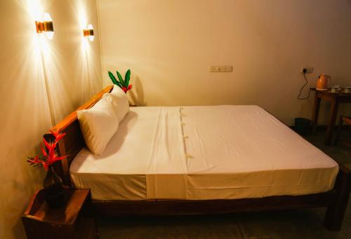 a bedroom with a bed with white sheets and pillows at Paradise Beach House - 3 Bedrooms Apartment in Habaraduwa in Habaraduwa
