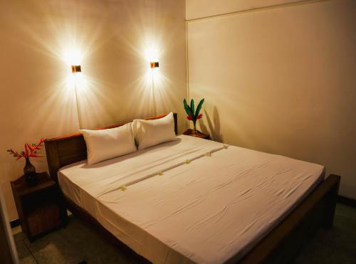 a bedroom with a large white bed with two pillows at Paradise Beach House - 3 Bedrooms Apartment in Habaraduwa in Habaraduwa