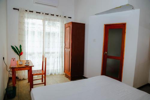 a bedroom with a bed and a table and a window at Paradise Beach House - 3 Bedrooms Apartment in Habaraduwa in Habaraduwa