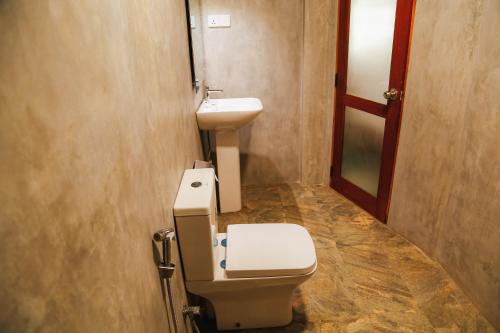 a bathroom with a toilet and a sink at Paradise Beach House - 3 Bedrooms Apartment in Habaraduwa in Habaraduwa