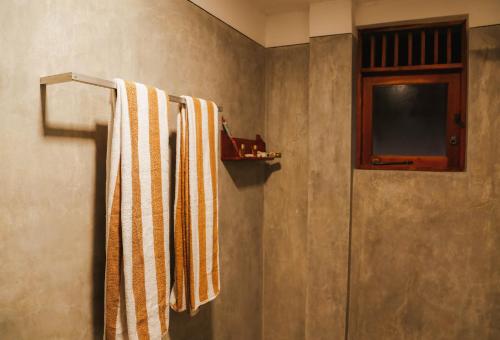 a bathroom with a towel rack and a television at Paradise Beach House - 3 Bedrooms Apartment in Habaraduwa in Habaraduwa Central
