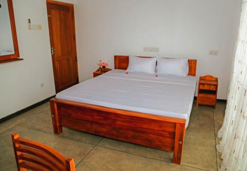 a bedroom with a large bed with white sheets at Paradise Beach House - 3 Bedrooms Apartment in Habaraduwa in Habaraduwa
