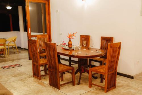 a dining room table with wooden chairs and a table and chairsktop at Paradise Beach House - 3 Bedrooms Apartment in Habaraduwa in Habaraduwa