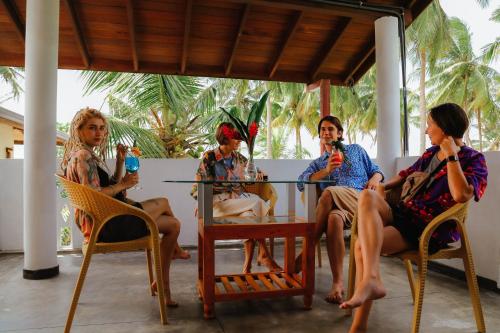 a group of people sitting around a table at Paradise Beach House - 3 Bedrooms Apartment in Habaraduwa in Habaraduwa