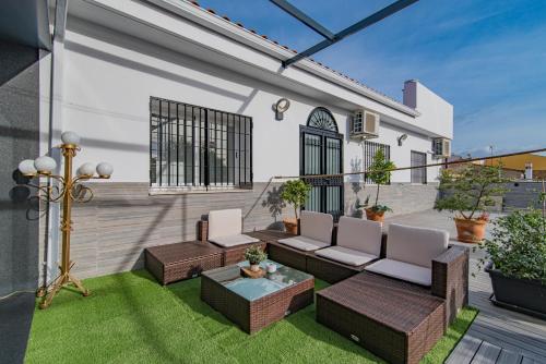 a patio with couches and a table on the grass at VESCI FAVENTIA in Huétor-Tájar