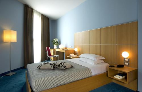 a hotel room with a large bed and a desk at Hotel Delle Fiere in Mozzate