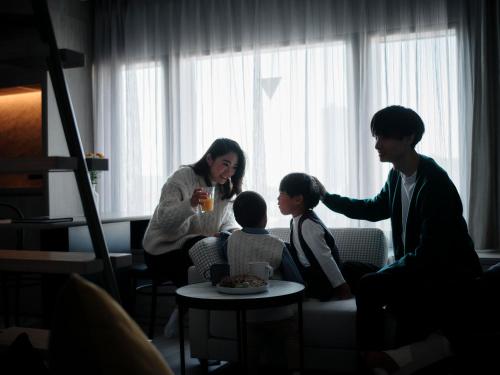 a woman and two children sitting in a room at fav HIROSHIMA HEIWAODORI in Hiroshima