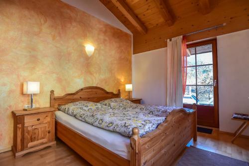 sypialnia z drewnianym łóżkiem i oknem w obiekcie Appartement Haus Schröder w mieście Söll