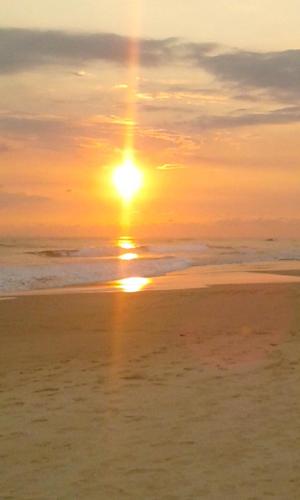 a sunset on the beach with the sun in the sky at Paradise Beach House - 3 Bedrooms Apartment in Habaraduwa in Habaraduwa