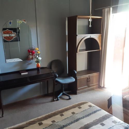 Midway Accommodation في سد غاريب: غرفة نوم مع مكتب ومرآة وكرسي
