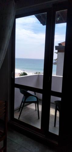 a view of the beach from a window with a table at Paradise Beach House - 3 Bedrooms Apartment in Habaraduwa in Habaraduwa