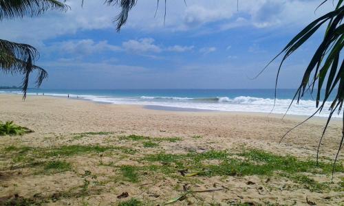 a sandy beach with the ocean in the background at Paradise Beach House - 3 Bedrooms Apartment in Habaraduwa in Habaraduwa