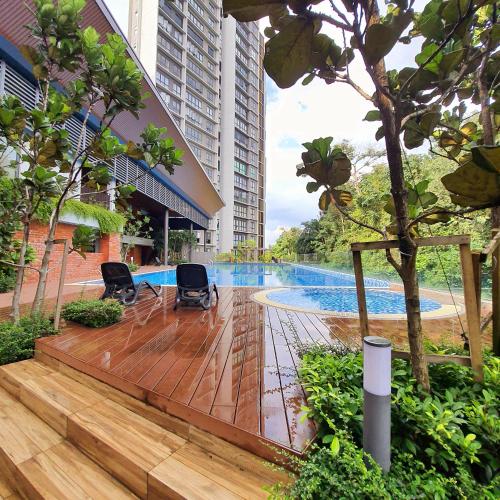 a deck with chairs and a pool in a building at The Glass Homestay Putrajaya in Putrajaya