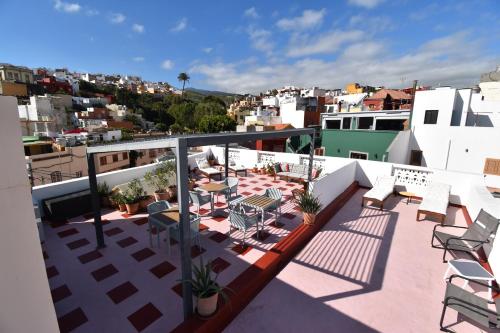 a balcony with chairs and tables on a building at Villa Nestor in Ingenio