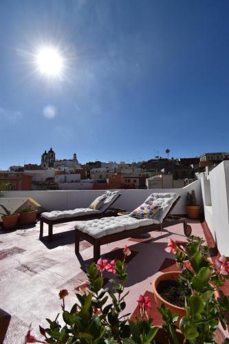 a balcony with two lounge chairs on a roof at Villa Nestor in Ingenio