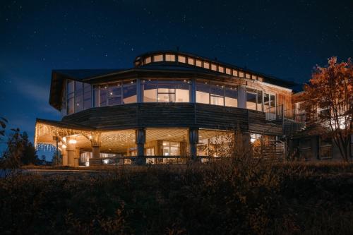 a large building with glass windows at night at Lapland Hotels Ylläskaltio in Äkäslompolo