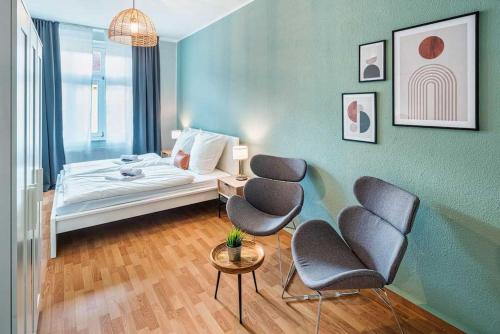 Cette chambre comprend un lit, deux chaises et une table. dans l'établissement cozy Apartment -Kerner- in Meißen mit MagentaPlus, à Meissen
