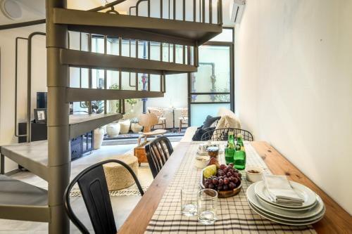 a dining room with a table with plates and wine bottles at Cozy Modern 1BR Duplex Apt w Balcony Near City Center by Sea N' Rent in Tel Aviv
