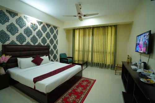 a hotel room with a bed and a television at Grand Mostafa Hotel Ababil in Sylhet