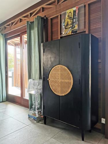 a black cabinet with a circular door in a room at Kaz C2C - Une maison Balinaise avec jacuzzi in Saint-Pierre