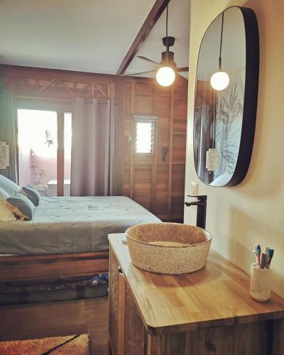 a bedroom with a bed and a bowl on a table at Kaz C2C - Une maison Balinaise avec jacuzzi in Saint-Pierre