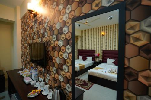 a mirror in a hotel room with two beds at Grand Mostafa Hotel Ababil in Sylhet