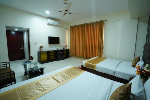 a hotel room with a bed and a television at Grand Mostafa Hotel Ababil in Sylhet
