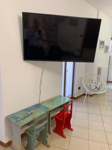 a flat screen tv hanging on a wall with a table at Casavacanze IL GALLO in Omegna