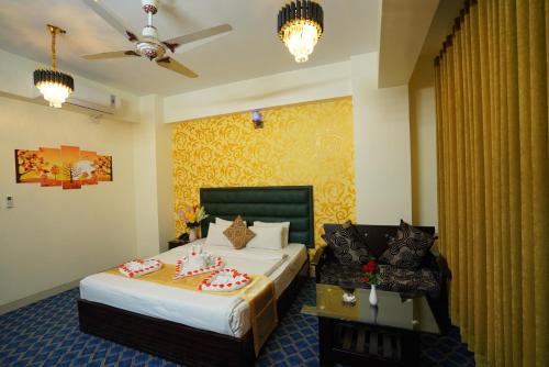 a hotel room with two beds and a couch at Grand Mostafa Hotel Ababil in Sylhet
