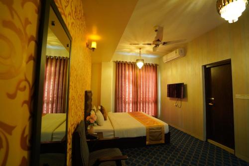 a hotel room with a bed and a mirror at Grand Mostafa Hotel Ababil in Sylhet