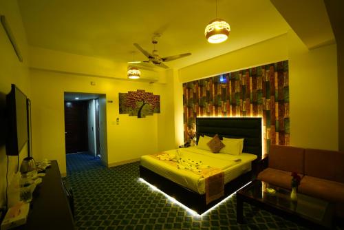 a bedroom with a bed and a couch in a room at Grand Mostafa Hotel Ababil in Sylhet