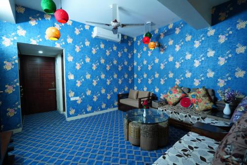 a living room with blue wallpaper and a couch at Grand Mostafa Hotel Ababil in Sylhet
