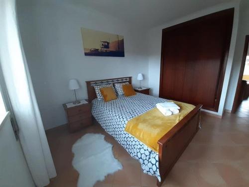 una camera da letto con un letto e un tappeto sul pavimento di Sun & Surf Flat Arrifana Beach ad Aljezur