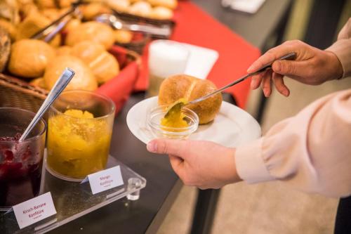 a person holding a plate of food on a table at Erbacher Hof, Bistum Mainz in Mainz
