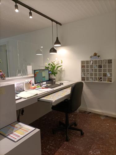 an office with a desk with a computer and a chair at Hotel Ai Pini in Grado