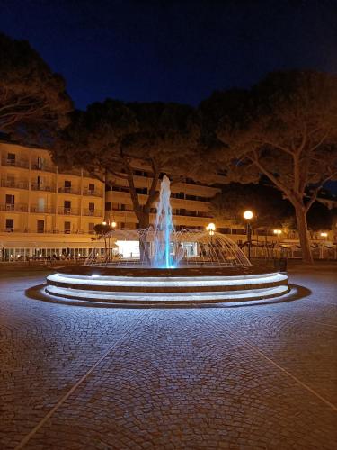 a fountain in the middle of a courtyard at night at Hotel Ai Pini in Grado