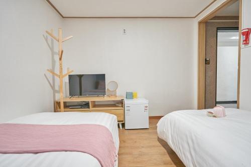 a room with two beds and a tv in it at K'STAY Sinchon in Seoul