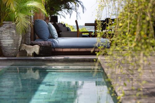 a swimming pool with a chaise lounge next to a swimming pool at Clay Beach Samui - Beachfront Villas in Amphoe Koh Samui