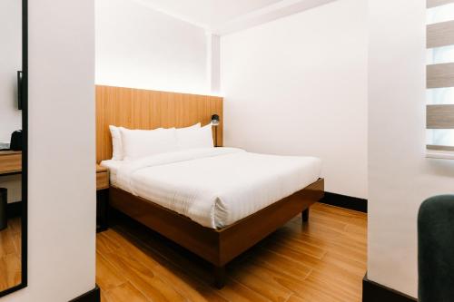 a bedroom with a bed with a wooden headboard at El Sancho Hotel in Naga