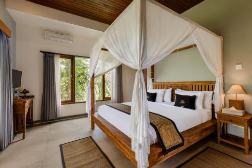 ein Schlafzimmer mit einem Himmelbett in der Unterkunft Kubu Rama Ubud Cottage in Ubud