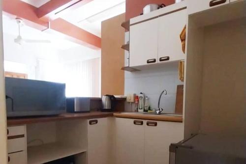 a kitchen with white cabinets and a window at Spacious 1 Bedroom, Self Catering Apartment in Glenwood, Durban in Durban