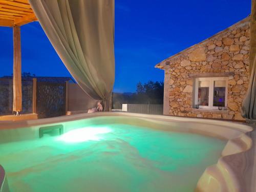 - une piscine en face d'une maison la nuit dans l'établissement L'antre deux Pierres, suite de charme, romantisme, jacuzzi privé, braséro, à Bouyon