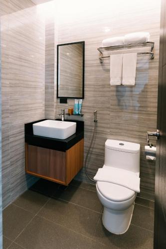 a bathroom with a white toilet and a sink at El Sancho Hotel in Naga
