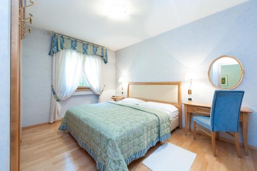 1 dormitorio con cama, escritorio y espejo en Residence Werth en Bolzano