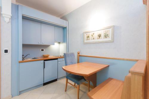 una piccola cucina con tavolo in legno e una sala da pranzo di Residence Werth a Bolzano